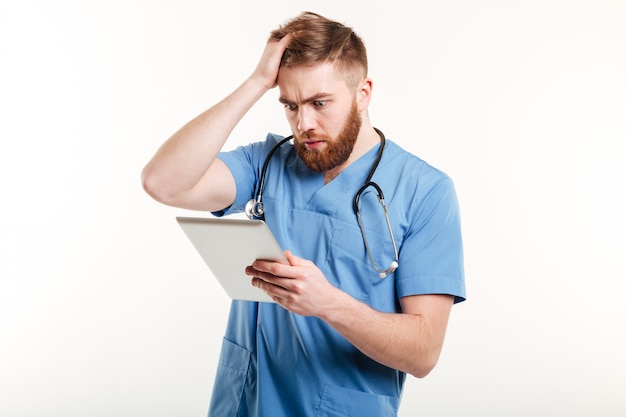 Free photo portrait of a surprised young doctor in blue uniform