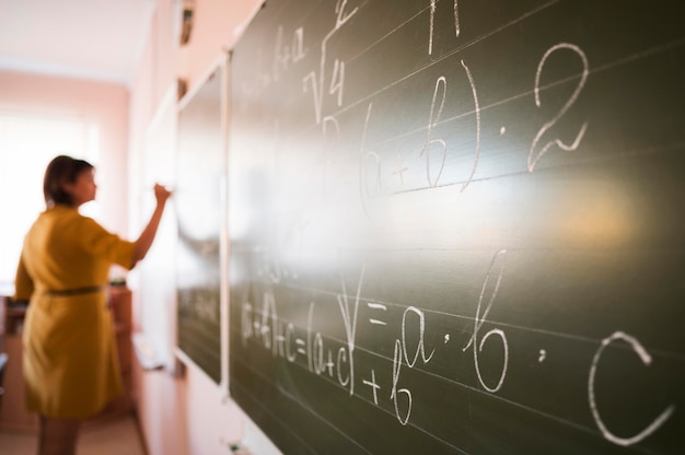 Free photo portrait teacher writing on chalkboard