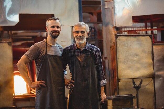 Portrait of team of glassblowers with hands on hip