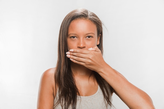 Free Photo portrait of a teenage girl covering her mouth