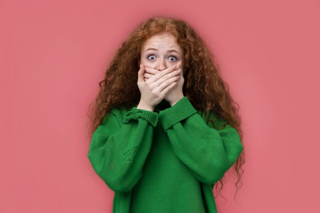 Portrait of teenage girl covering her mouth