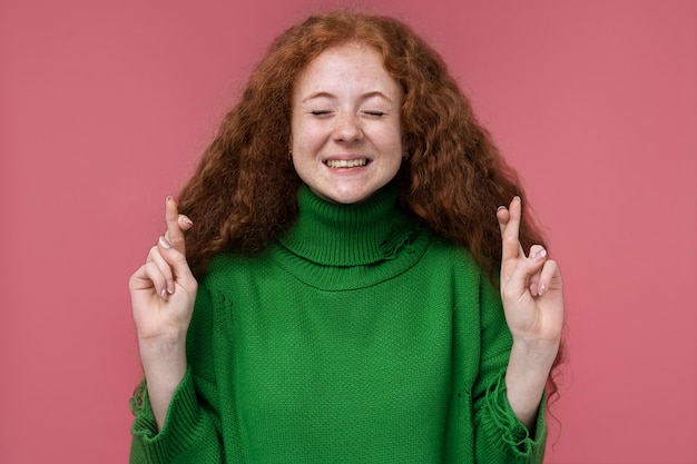 Free Photo portrait of teenage girl keeping her fingers crossed