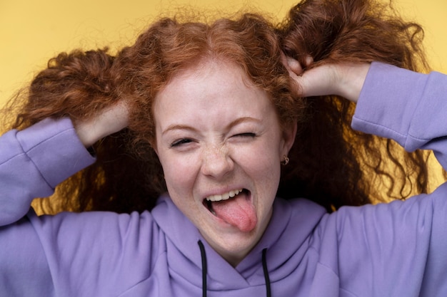 Portrait of teenage girl looking happy and sticking her tongue out