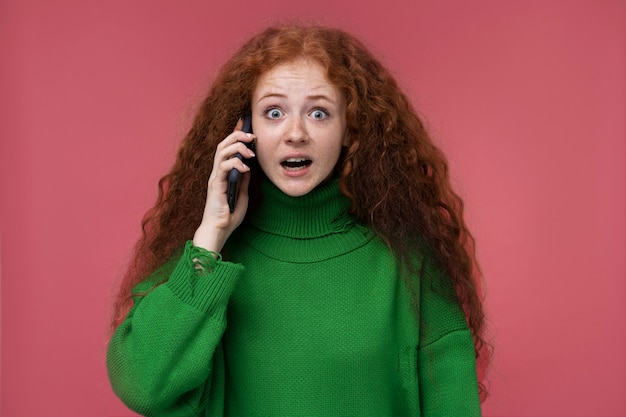 Portrait of teenage girl looking surprised while talking on the phone