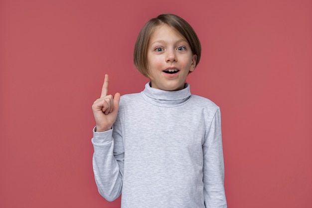 Portrait of teenage girl pointing up