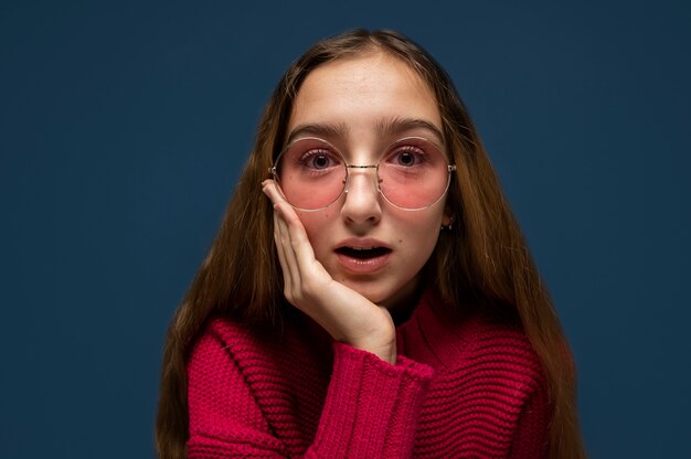 Portrait of a teenage girl wearing sunglasses and looking surprised