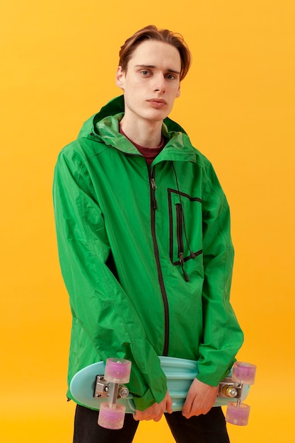 Free photo portrait teenager with green jacket and skateboard