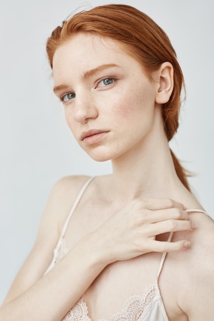 Free photo portrait of tender beautiful redhead girl  over white wall.