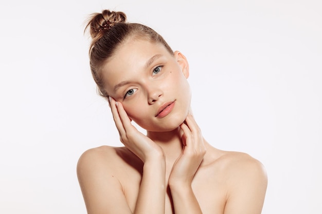 Free photo portrait of tender beautiful young girl with nude makeup posing isolated over white studio background natural beauty