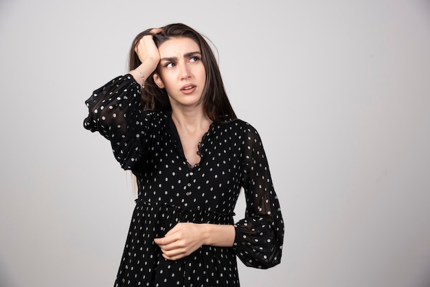 Portrait of thoughtful girl holding hands on head .