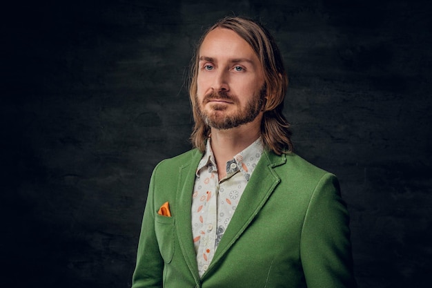 Free Photo portrait of thoughtful man with long hair and retro style at dark photo studio.