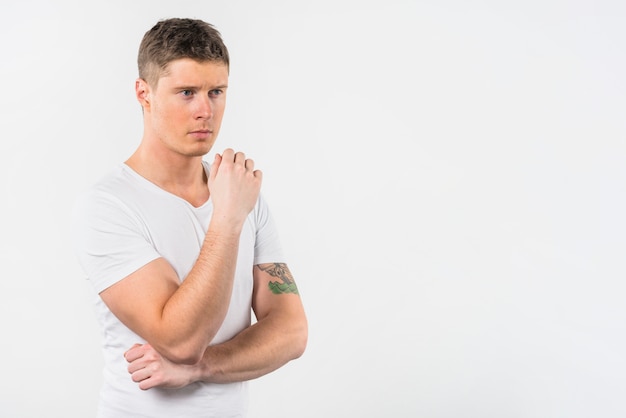 Portrait of a thoughtful young man standing against white background