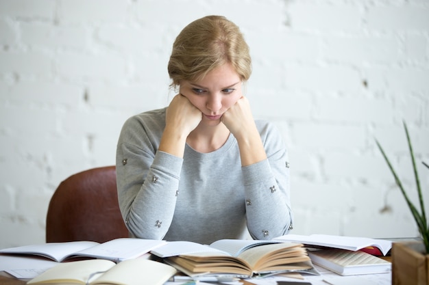 Free Photo portrait of a tired student woman at the desk