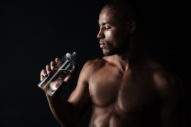 Portrait of tired young afro american sports man, holding bottle of water