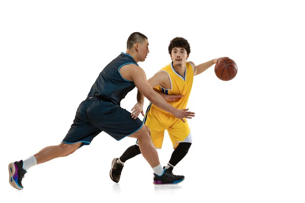 Portrait of two basketball players training dribbling isolated over white studio background