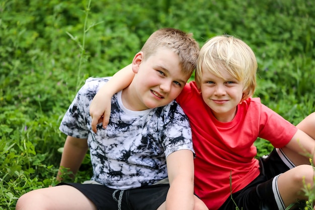 Free photo portrait of two blonde brothers smiling while hugging each other