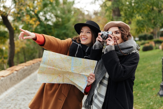 Free photo portrait of two cheerful girls dressed in autumn clothes