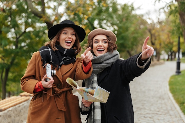 Free photo portrait of two cheerful girls dressed in autumn clothes