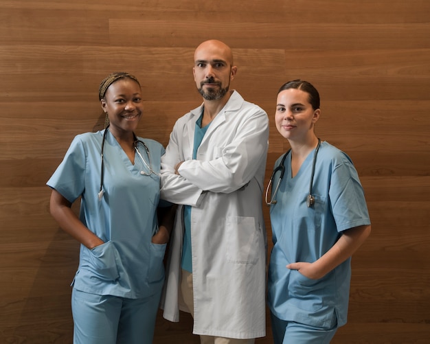 Portrait of two female nurses at the clinic in scrubs with male doctor