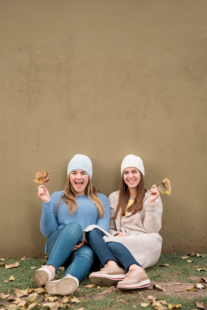 Free photo portrait of two girls in front of a wall