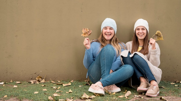 Portrait of two girls in front of a wall