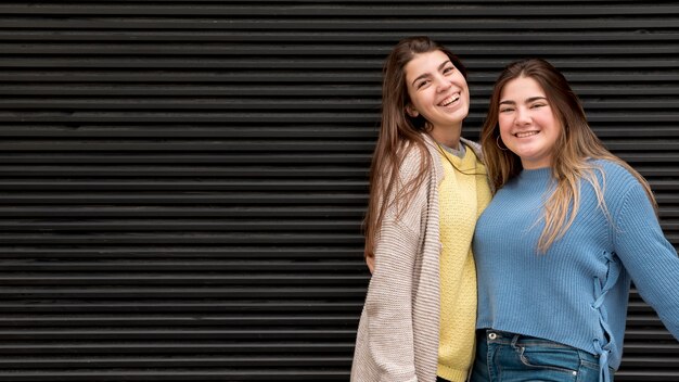 Portrait of two girls in front of a wall