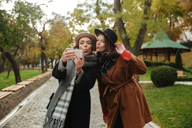 Portrait of two pretty girls dressed in autumn clothes