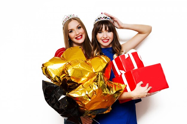 Free Photo portrait of two pretty women with bright party balloons and gift boxes