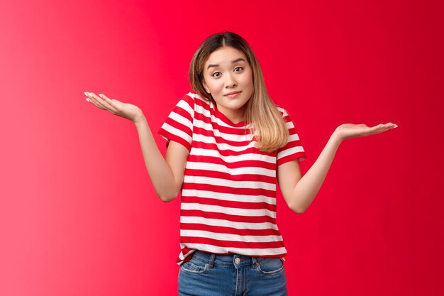 Portrait unbothered relaxed chill blond girl shrugging hands spread sideways clueless woman smiling ...