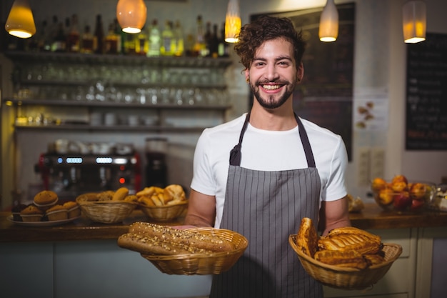 Free photo portrait of waiter holding a basket of bread