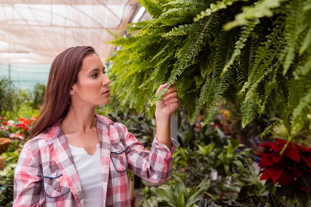 Free photo portrait of woman admiring plants in garden