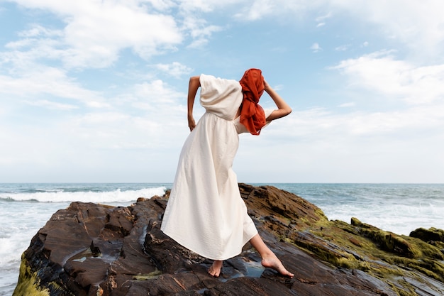 Portrait of woman at the beach covering her face with veil