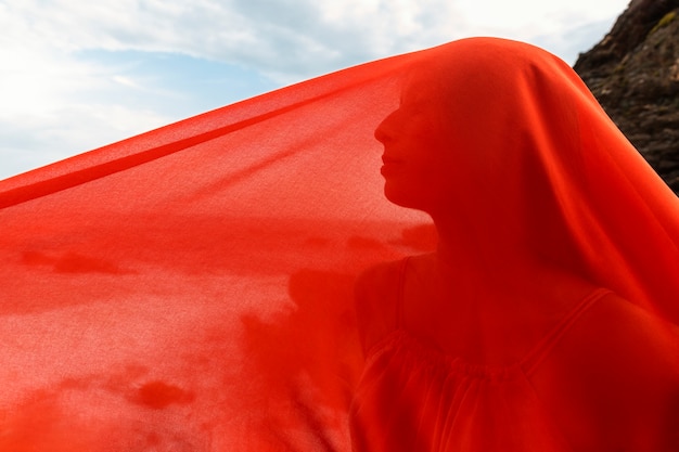 Free photo portrait of woman at the beach with face covered by veil