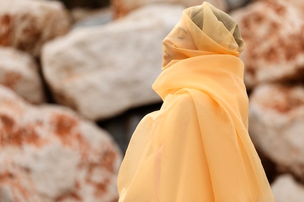 Free Photo portrait of woman at the beach with face covered by veil