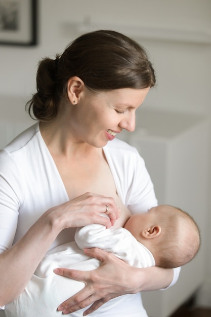 Portrait of a woman breastfeeding a child, on her hands