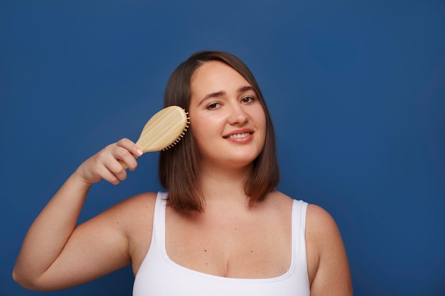 Portrait of woman brushing her hair as part of her beauty regimen