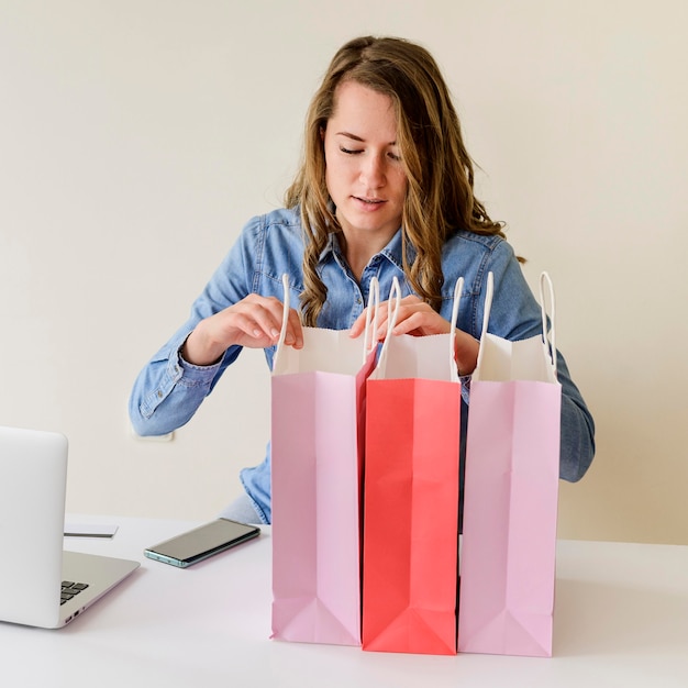 Free Photo portrait of woman checking shopping bags