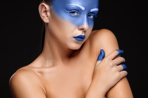 Portrait of a woman covered with blue paint