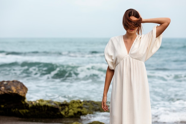 Portrait of woman covering her face with hair at the beach