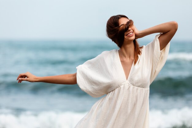 Portrait of woman covering her face with hair at the beach