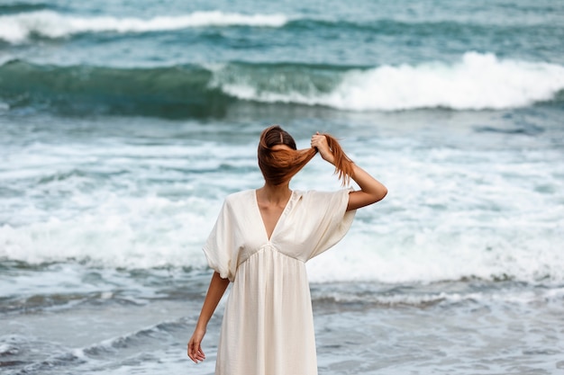 Free Photo portrait of woman covering her face with hair at the beach