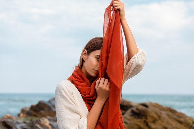 Portrait of woman covering her face with veil at the beach