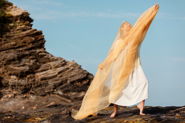 Free photo portrait of woman covering her face with veil at the beach