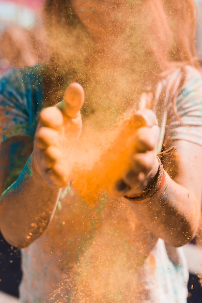 Free photo portrait of a woman dusting the holi powder with hands