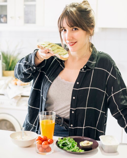 Portrait of a woman eating bread with avocado