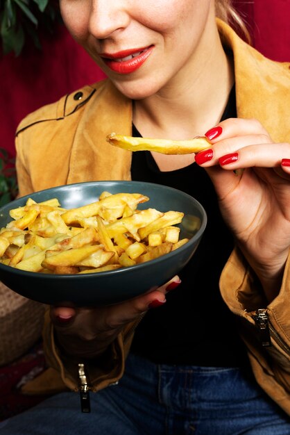 Portrait of woman eating a dish of poutine