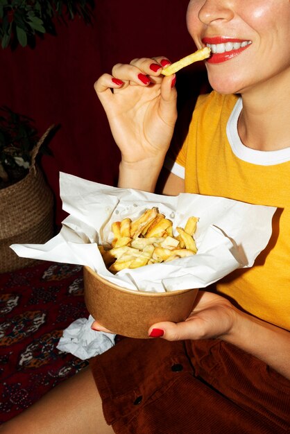 Portrait of woman eating a dish of poutine