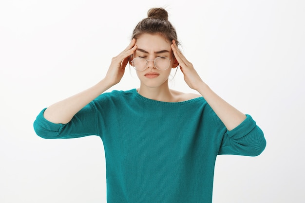 Portrait of woman in glasses having headache, feeling dizzy or have fever, migraine