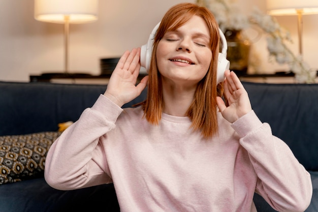 Free photo portrait woman at home listening music