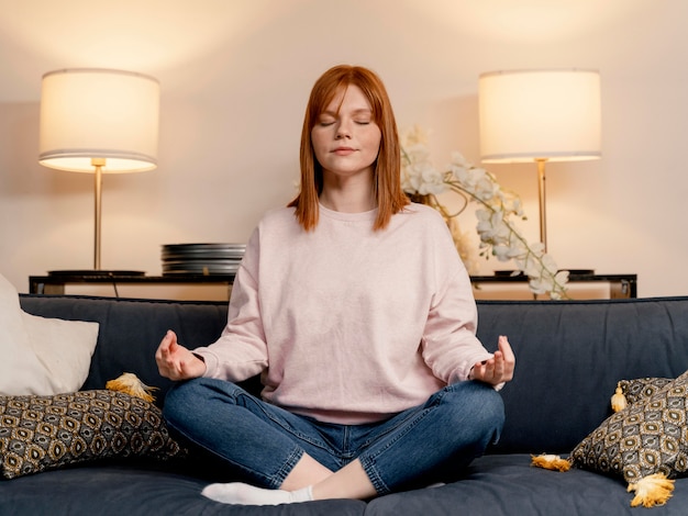 Free photo portrait woman at home meditating